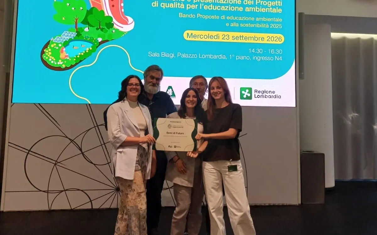 I rappresentanti di Auser Ambiente con l'attestato del progetto Semi di Futuro, sul palco di Palazzo Lombardia davanti allo schermo della premiazione
